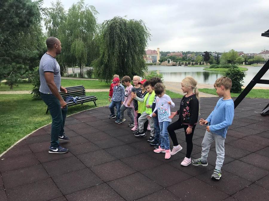 Группа детей с преподавателем у озера в Гринфилде