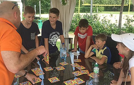 Мальчики играют в карточную игру на английском языке на воздухе
