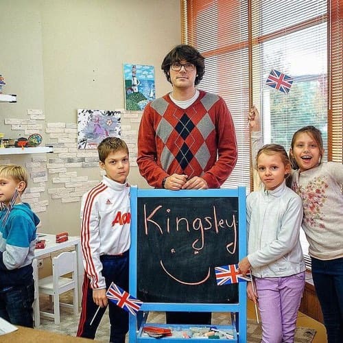 Преподаватель и дети у доски с надписью Kingsley